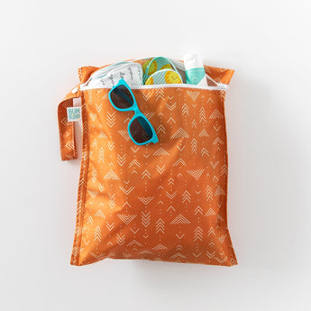Bumkins Wet Bag: Grounded holds sunglasses, sunscreen, and shoes on a white background.