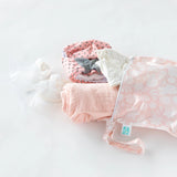 Bumkins Wet Bag: Lace lays on a white background, with a nursing cover, cloth diapers, & breast pump parts spilling out.