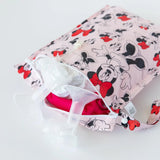 Bumkins Wet Bag: Minnie Mouse Classic sits partially open on a white background with cloth diapers and breast pump parts inside.