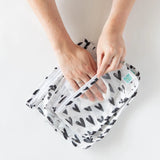 A person uses a cloth to clean the interior of Bumkins Clear Travel Bag 3-Pack: Hearts on a white background.