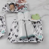Close-up of rolled cloths and a cactus-shaped teether in a Bumkins Clear Travel Bag 3-Pack: Hearts on a marble background.