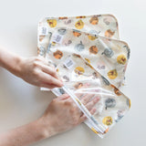 Hands using a cloth to clean the interior of Bumkins Clear Travel Bag 3-Pack: Winnie and Friends on a white background.
