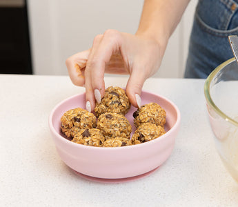 Finished no-bake lactation bites arranged in Bumkins silicone grip bowl, ready to eat.