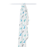 White muslin bamboo swaddle featuring a whales print by Lulujo Inc., hanging on a rod.
