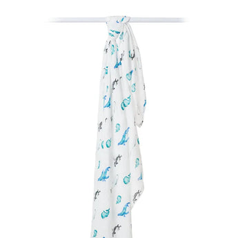 White muslin bamboo swaddle featuring a whales print by Lulujo Inc., hanging on a rod.