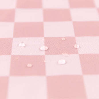 Close-up of water droplets on a Bumkins Wet Bag Plus 2 Pack: Mauve + Sand Check.