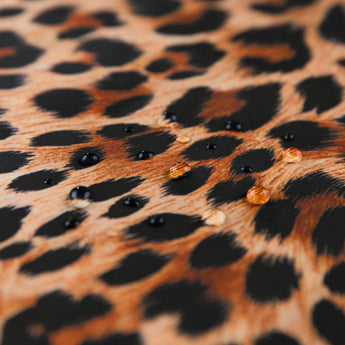 Close-up of water droplets on Roamio by Bumkins Wet/Dry Clutch: Leopard.