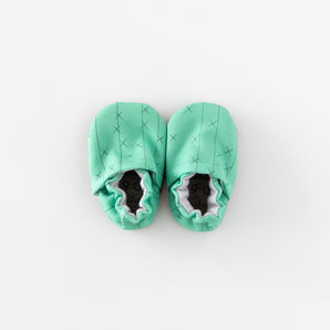 Cabooties Cactus Spines: Mint green baby booties with crisscross stitching and elastic closure, displayed on a white background.