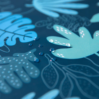 Close-up of water droplets on Bumkins Splat Mat: Blue Tropic.