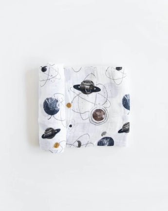 Lightweight cotton swaddle by Little Unicorn with space-themed prints of planets and stars. Folded neatly.
