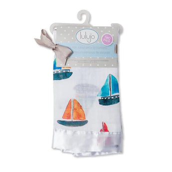 Lulujo Inc.s Security Blanket, Sailboats: 2-pack of cotton muslin cloths with sailboat designs, tied with a beige bow on a hanger.
