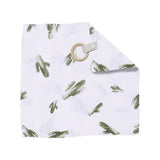 The Bebe Au Lait Muslin Teether Blanket features a white burp cloth with green cactus prints and a tan wood teether in one corner.