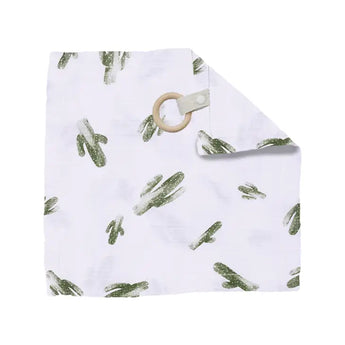 The Bebe Au Lait Muslin Teether Blanket features a white burp cloth with green cactus prints and a tan wood teether in one corner.