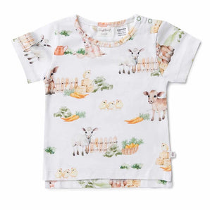 This Organic T-Shirt by Snuggle Hunny is crafted from certified organic cotton and features a farm-themed pattern with lambs, chicks, a calf, carrots, and a wooden fence against a crisp white background. It is made by an Australian-based company dedicated to creating high-quality organic T-shirts.