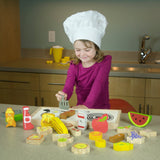 A child in a chef hat joyfully arranges Begin Agains Alphabites wooden puzzle pieces in a play kitchen like an educational game.