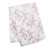 Lulujo Inc.s Cotton Swaddle, Unicorn: a white cotton blanket with pink unicorns & colorful flowers for cozy snuggles.