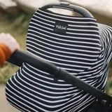 Milk Snobs Cover Modern Stripe on a baby stroller outdoors, with a hand pushing it.