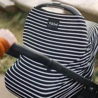 Milk Snobs Cover Modern Stripe on a baby stroller outdoors, with a hand pushing it.