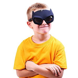 A child with a yellow shirt, cat ears mask, and Lil Characters Sunglasses (Sunstaches) channels Batman, smiling confidently with crossed arms.