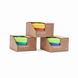 Three stackable morepeas Essential Snack Bowls with suction bases come in green, yellow, and blue pyramid-style cardboard boxes.