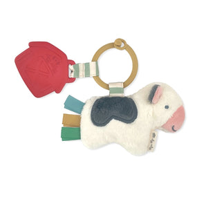 Itzy Pal Cow: red silicone barn and white & gray plush cow attached to tan silicone ring with cream & green striped fabric.