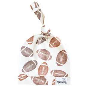 Copper Pearls Blitz Top Knot Hat: White with a football pattern in brown & tan; ultra-soft, adjustable knot.