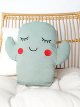 The Bamboo Pillow, Cactus by Emerson and Friends sits on a chair, ultra-soft with Poly-fil stuffing, featuring a smiley face and red cheeks.