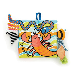 The Jellycat Sea Tails Cloth Book features a cheerful lobster, eel, and textured tabs for sensory fun with ocean pals.