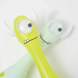 Monty the Monster and his cartoon pal, one-eyed horned figures with silly smiles, lie side by side like Sunnylife pool noodles.