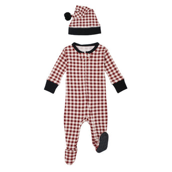 The Lovedbaby Holiday Zipper Footie & Cap in Crimson Plaid features a red and white checkered onesie with black trim and a matching hat with a black pom-pom. Made from organic cotton, it ensures easy diaper changes and is laid flat on a white background for a chic look.