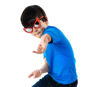 A young boy in a blue shirt playfully poses wearing Sunstaches Lil Characters Sunglasses, Spiderman Miles Morales, on a white background.