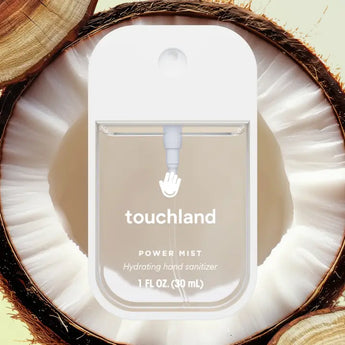 Hydrating Hand Sanitizer: clear sanitizer bottle with white cap & text "touchland Power Mist Hydrating hand sanitizer" on a coconut half