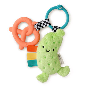 Itzy Pal, Parker the Pickle: teal silicone ring with green plush pickle and orange silicone pretzel attached by black & white check fabric.
