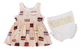 The Blake Birdie Peplum Set by Birdie Bean features a sleeveless cake print dress and ivory ruffled bloomers for a charming look.