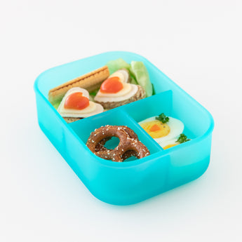 Bumkins Silicone Bento Box 3 Section: Blue Jelly holds heart-shaped egg slices on crackers, boiled eggs, and pretzels on a white background.