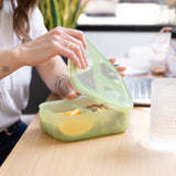A person opens a bento box with snacks from Bumkins Lunchbox Legends 6-Piece Set: Motley Green Jelly at a desk.