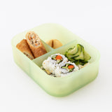 A bento box from Bumkins Lunchbox Legends 6-Piece Set: Motley Green Jelly with sushi and egg rolls sits on a white background.