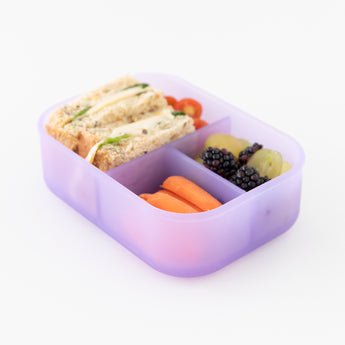 A bento box from Bumkins Lunchbox Legends 6-Piece Set: Coastal Purple Jelly holds a sandwich, fruit, & veggies on a white background.