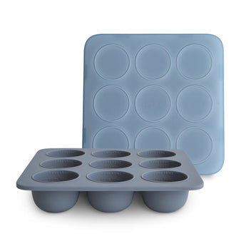 The Mushie Baby Food Freezer Tray, Tradewinds, is BPA-free silicone with 6 cups. One tray is upright; the other is upside down.