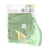 Bumkins Ruffle Apron Bib: Tiana is shown folded on a white cardboard packaging header.