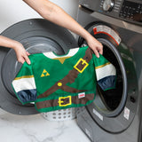 A person holds a bib from Bumkins Snack In Character 4-Piece Set: Nintendo Zelda in front of an open front-loading washing machine.