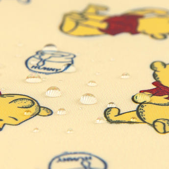 Close-up of water droplets on Bumkins Wet/Dry Clutch: Winnie Loves Hunny.