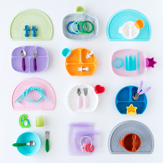 Flatlay of colorful silicone dishware neatly arranged on a white background.