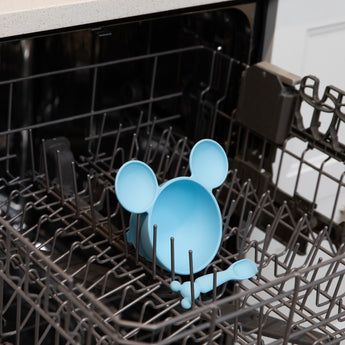 Bumkins Silicone First Feeding Set: Mickey Mouse Light Blue sits in the top rack of an open dishwasher.