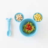 Bumkins Silicone First Feeding Set: Mickey Mouse Light Blue filled with chicken, corn, and mashed avocado on a white background.