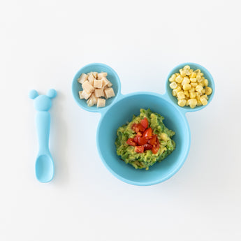 Bumkins Silicone First Feeding Set: Mickey Mouse Light Blue filled with chicken, corn, and mashed avocado on a white background.