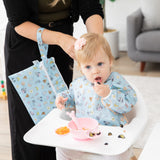 A mom and baby use Bumkins On-The-Go Mealtime 5-Piece Set: Mickey + Minnie Mouse Sunny Side Up Pink at meal time in a cozy living room.
