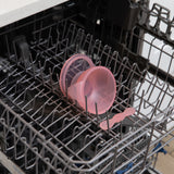 Bumkins Silicone First Feeding Set: Pink Jelly sits in the top rack of an open dishwasher.