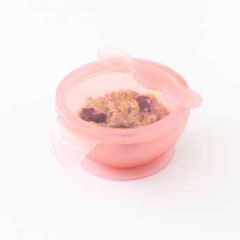 Bumkins Silicone First Feeding Set: Pink Jelly sits on a white background, filled with oatmeal and berries.