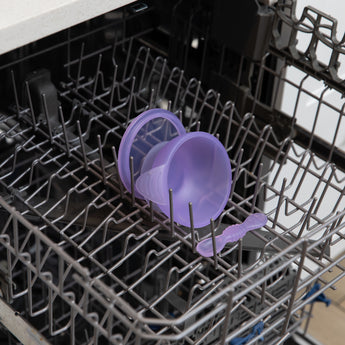 Bumkins Silicone First Feeding Set: Purple Jelly sits in the top rack of an open dishwasher.